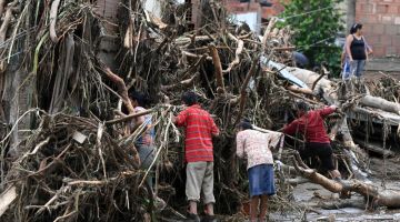 Penduduk menggeledah puing untuk mencari ahli keluarga yang hilang susulan tanah runtuh semasa hujan lebat melanda Las Tejerias di negeri Aragua, kelmarin. — Gambar AFP