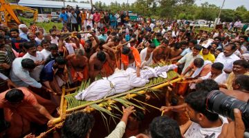 Orang ramai mengangkat buaya Babia di kuil tasik Ananthapura semasa upacara penguburan di Kasaragod, negeri Kerala kelmarin. — Gambar AFP