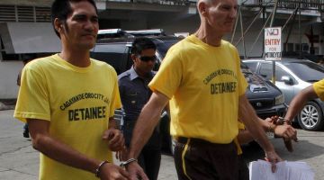 DIPENJARA: Gambar fail pada 16 Jun, 2015 menunjukkan Scully (kanan) digari bersama seorang banduan lain ketika meninggalkan mahkamah di bandar Cagayan de Oro, Mindanao. — Gambar AFP 