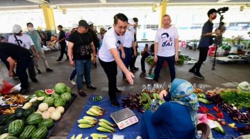 PRIHATIN: Mohd Azis bersama pengundi di Tamu Bataras Kolombong, hari ini.