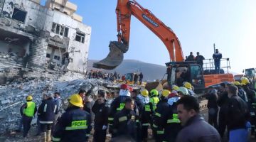 Orang ramai berkumpul ketika anggota bomba menggeledah runtuhan bangunan untuk mencari mangsa terselamat selepas letupan tangki gas di bandar  Sulaimaniyah, di utara Iraq kelmarin. — Gambar AFP