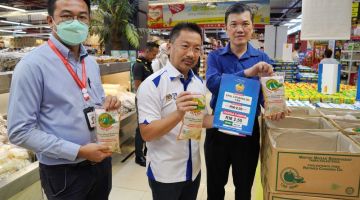 JOM BELI: (Dari kiri) Ariston, Peter dan Wong menunjukkan minyak masak pek Epal yang dijual pada harga RM2.50 sebungkus. - Gambar Chimon Upon