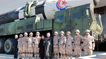 Gambar tidak bertarikh serahan KCNA semalam menunjukkan Kim bersama anak perempuannya bergambar bersama anggota tentera yang terlibat dalam ujian pelancaran ICBM di lokasi tidak didedahkan di Korea Utara. - Gambar AFP