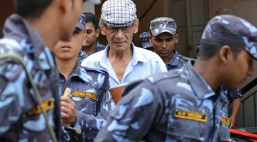 Gambar fail menunjukkan Sobhraj (tengah) diiringi beberapa anggota polis Nepal di mahkamah daerah untuk pendengaran kes berhubung dengan pembunuhan pelancong Kanada Laurent Ormond Carriere di Bhaktapur pada 12 Jun, 2014. — Gambar AFP