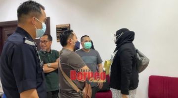 Wazien (dua kanan) bercakap bersama peguamnya, Fadzillah (kanan) semasa berada di lobi Kompleks Mahkamah Kuching petang tadi. Turut kelihatan, ahli keluarga Wazien. 