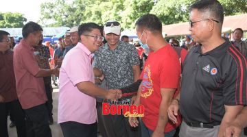 SELAMAT DATANG: Ewon bersalaman dengan penduduk yang hadir dalam majlis berkenaan.