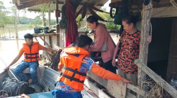 BANJIR: Penduduk di Kampung Saab yang terjejas banjir dipindahkan ke kawasan selamat.