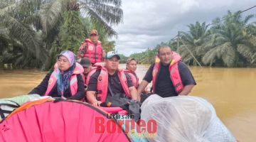 BANTUAN: Pasukan bomba membantu menghantar bantuan bekalan makanan di PPS Pamol.