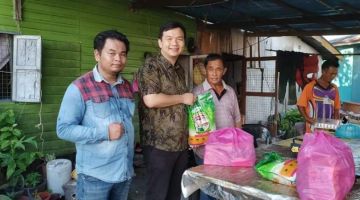 Chiew (dua kiri) menyampaikan sumbangan makanan kepada salah sebuah keluarga di Kampung Muhibbah Kuala Baram pada Jumaat. 