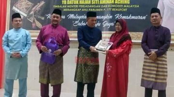 HADIAH: Jaludin menyampaikan hadiah kepada salah seorang peserta qariah sambil diperhatikan oleh Joumat.