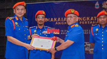 PANGKAT: Armizan (kiri) menyampaikan sijil kepada pegawai yang menerima pemakaian pangkat pada majlis itu.