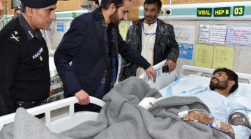 Ketua Menteri Balochistan Mir Abdul Qudoos Bizenjo (dua kiri) berbual dengan anggota polis yang menerima rawatan di hospital di Quetta selepas tercedera dalam serangan bom nekad di daerah Kachhi kelmarin. — Gambar AFP