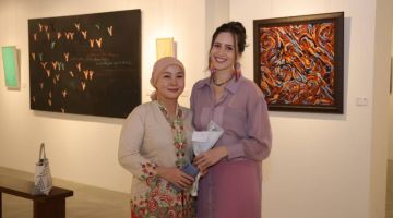 ORANG SENI: Alena (kanan) merakam kenangan bersama Pereka Fesyen Sarawak Neng Kho Razali (kiri) di pameran 'Colours of the Highlands' di Galeri Hoan, La Promenade Mall malam tadi.