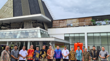 Tan  (lima kanan) merakamkan kenangan bersama Raden Sigit (enam kanan) serta yang lain di hadapan bangunan Marketing Point Entikong, Kalimantan Barat, Indonesia.