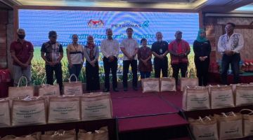 (Dari lima kiri) Anuar dan Juan bersama pegawai Petronas yang lain dan enam daripada penerima yang menerima sumbangan sebagai simbolik penyerahan bantuan Gawai 2023 di Miri hari ini. 