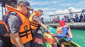 PERIKSA: Azdy membuat pemeriksaan ke atas bot-bot di kawasan perairan pulau tersebut.