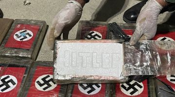 HASIL RAMPASAN: Gambar serahan Polis Negara Peru menunjukkan bungkusan kokain dengan lambang swastika Nazi dan nama Hitler yang dirampas dari sebuah kapal kontena di pelabuhan Paita, Peru kelmarin. — Gambar AFP