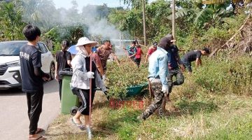 BERSAMA: Penduduk Kg Agudon bergotong royong membersihkan persekitaran kampung sempena program itu.