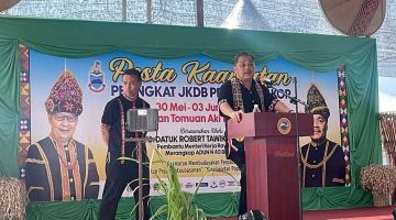 RASMIKAN: Robert (kanan) ketika menyampaikan ucapan bagi merasmikan sambutan Pesta Kaamatan JKDB Pekan Bingkor di Dewan Tamuon Aki Tingadon Pantayan.