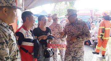 PENERANGAN: Shahrizan (kanan) memberi penerangan kepada pengunjung yang datang di tapak pameran Maritim Malaysia.