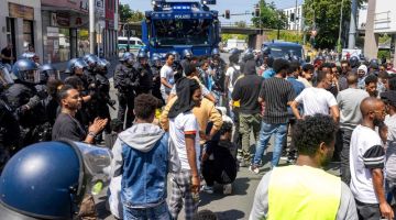 KAWAL: Polis Jerman berhadapan dengan peserta Festival Eritrea di Giessen, Hessen kelmarin, kelihatan kenderaan polis dilengkapi meriam air di belakang.  — Gambar AFP