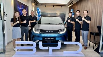Ketua bahagian pengedar Regas EV Auto Sdn Bhd, Brandon Juan bersama yang lain di bilik penghantaran kenderaan elektrik BYD di CityOn, Kuching. - Gambar Roystein Emmor