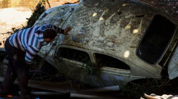 Seorang lelaki memeriksa kereta yang rosak selepas siklon melanda bandar Mucum di negeri selatan Rio Grande do Sul kelmarin. — Gambar AFP