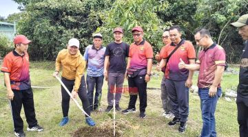 SIMBOLIK: Mazlan (dua kiri) sedang menanam pokok sebagai simbolik Program Gotong Royong Madani SK Lupak.