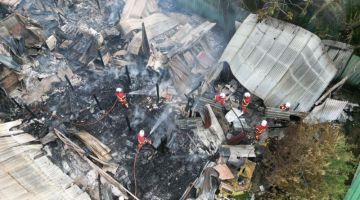 RENTUNG: Pasukan bomba menjalankan operasi memadam kebakaran membabitkan enam buah rumah di Kampung Pulutan, Manggatal, di sini.