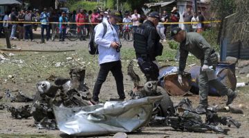 Anggota unit antibom polis memeriksa lokasi di mana sebuah bom kereta meletup di luar balai polis di Potrerito, Valle del Cauca kelmarin. — Gambar AFP