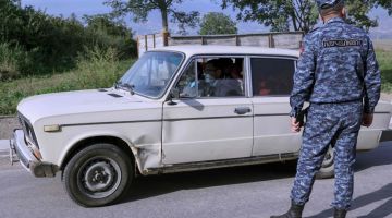 Seorang pegawai polis Armenia memeriksa kenderaan yang membawa pelarian ketika tiba di pusat pendaftaran, dekat sempadan Kornidzor, kelmarin. — Gambar AFP