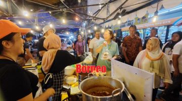 TINJAU: Christina (tiga kanan) dan Noorliza (kanan) ketika melawat penjaja di Api-Api Night Food Market.