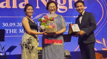 KENANGAN: Christina (tengah) menerima cendera kenangan daripada Presiden SLS Roger Chin (kanan), turut kelihatan Pengerusi Penganjur Yee Tsai Yiew.