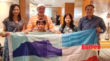 KENANGAN: Zen dan Tia ditemani ibu bapa mereka sedang memegang bendera Sabah bersama Hajiji (dua kiri) ketika dalam pertemuan itu.