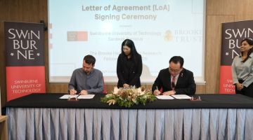 Jason Brooke (duduk kiri) dan Lau (duduk kanan) menandatangani LoA sambil disaksikan Timbalan Naib Canselor (Penyelidikan) Swinburne Sarawak Profesor Dr Ida Fatimawati Adi Badiozaman.