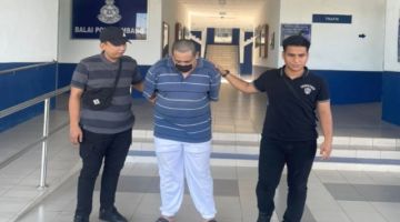 Tertuduh (tengah) diiringi anggota polis ke Mahkamah Majistret Limbang.