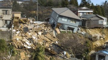 Rumah-rumah rosak akibat gempa bumi, termasuk satu yang musnah sepenuhnya, di Wajima, Jepun. - Gambar AFP