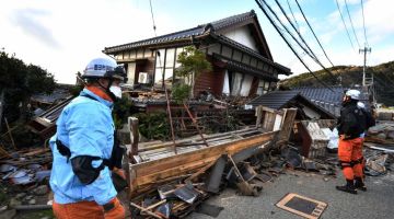 Anggota bomba memeriksa rumah kayu yang roboh di Wajima, wilayah Ishikawa semalam, sehari selepas gempa bumi 7.5 pada skala Richter melanda daerah Noto di wilayah Ishikawa pada sebelah petang. — Gambar AFP