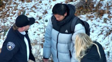Gambar Jabatan Polis Riverdale kelmarin menunjukkan polis berbual dengan Kai Zhuang berhampiran tapak di mana dia ditemui di gunung dekat Bandar Brigham, Utah pada Ahad selepas dilaporkan hilang. — Gambar AFP