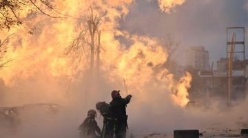 Anggota bomba Ukraine cuba memadamkan api yang marak selepas serangan peluru berpandu di Kyiv kelmarin. — Gambar AFP