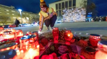 Seorang lelaki menyalakan lilin di sebelah potret Navalny semasa acara memberi penghormatan terakhir kepada ketua penentang Rusia itu di pusat bandar Zagreb pada 23 Februari lepas. — Gambar AFP