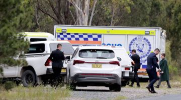 Pasukan polis New South Wales memeriksa lokasi di Bungonia kelmarin di mana mereka menemui mayat seorang pengacara televisyen dan teman lelakinya yang merupakan seorang pramugara. — Gambar AFP