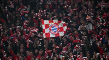 Peminat mengibarkan bendera Bayern Munich ketika menyaksikan perlawanan Liga Juara-Juara di antara Bayern Munich dan Lazio pada awal bulan lalu. — Gambar AFP