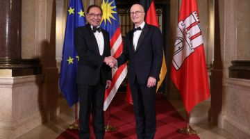 Anwar bersalam dengan Datuk Bandar Hamburg Peter Tschentscher ketika hadir bagi menyampaikan ucap tama pada acara 101st Ostasiatisches Liebesmahl di Hamburg City Hall, semalam.-Gambar BERNAMA