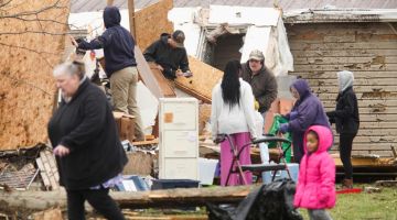 Mangsa puting beliung saling membantu untuk membersihkan kawasan rumah mereka yang terjejas teruk di Indian Lake, Ohio. - AFP