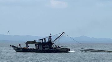 TAHAN: Salah sebuah bot nelayan yang ditahan selepas menarik pukat kurang dua batu nautika dari daratan.