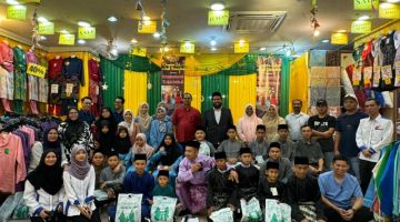 KENANGAN: Dinie merakamkan gambar kenangan bersama penerima semasa Program Infaq Kasih Ramadan 2024 di sini.