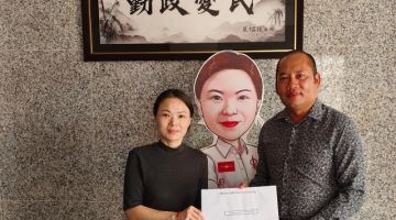 Lau (kiri) menyerahkan sumbangan untuk penganjuran Liga Perpaduan - Alice Lau Kiong Yieng kepada Lorentossa (kanan).