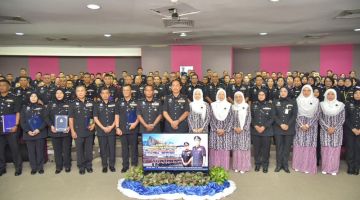 KENANGAN: Jauteh merakamkan gambar kenangan bersama pegawai serta anggotanya semasa Peringatan Hari Polis ke-217 di IPK Sabah di sini.