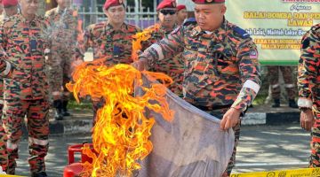 Seorang anggota bomba menunjukkan cara memadam api pada Kempen Keselamatan Kebakaran Musim Perayaan Hari Raya Aidilfitri 2024 di Lawas.